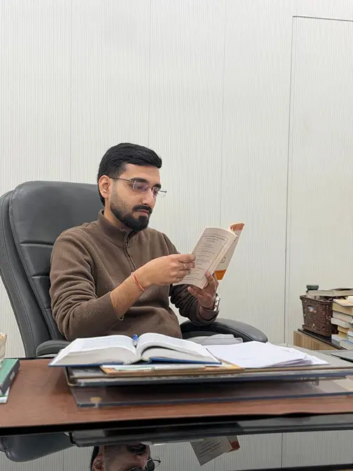 Dr. Yashasvi Verma reading at his clinic desk