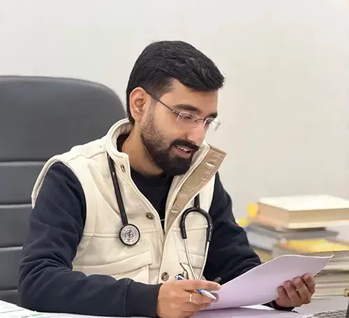 Dr. Yashasvi Verma reviewing papers at his clinic desk